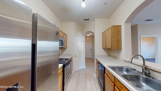 kitchen featuring sink, black appliances, and light tile patterned flooring