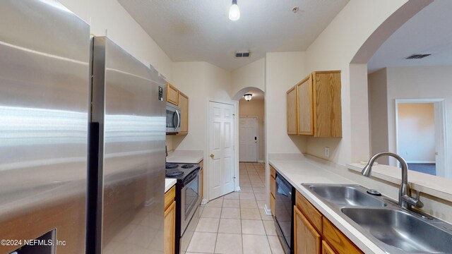 7990 Baymeadows Rd E Unit 410, Jacksonville, FL 32256 - kitchen with stainless steel appliances, a sink, arched walkways, light tile patterned floors, and light countertops