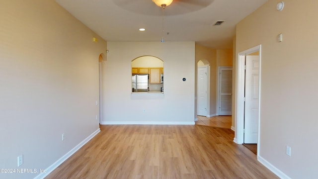 spare room with light wood-type flooring and ceiling fan