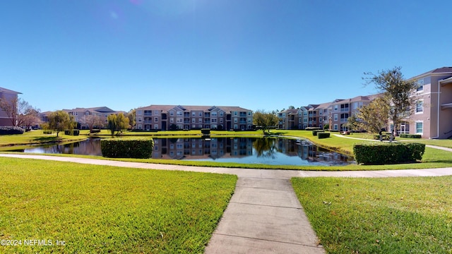 surrounding community with a yard and a water view