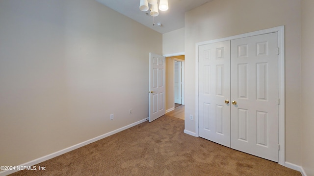 unfurnished bedroom featuring a closet and light colored carpet