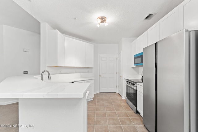 kitchen with kitchen peninsula, light stone countertops, a textured ceiling, stainless steel appliances, and white cabinets