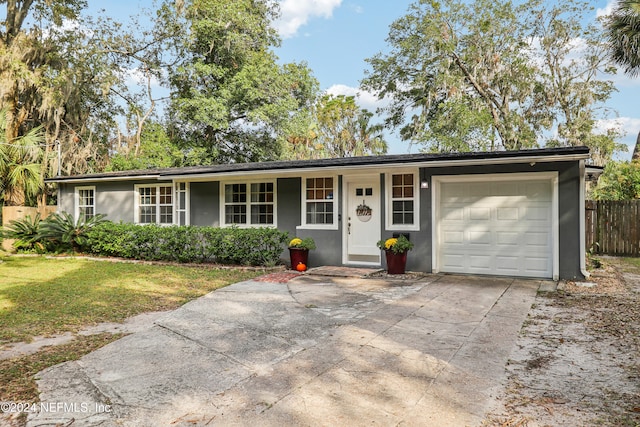 ranch-style house featuring a front lawn and a garage