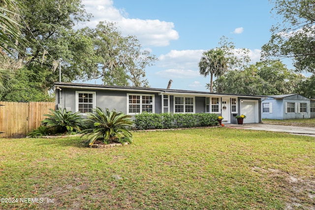 ranch-style home with a garage and a front lawn