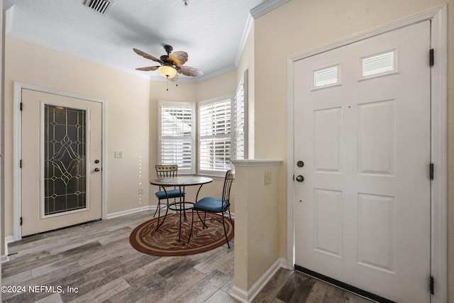 foyer entrance featuring crown molding, hardwood / wood-style flooring, a textured ceiling, and ceiling fan