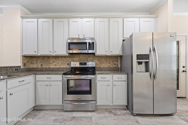 kitchen featuring appliances with stainless steel finishes, decorative backsplash, and white cabinets