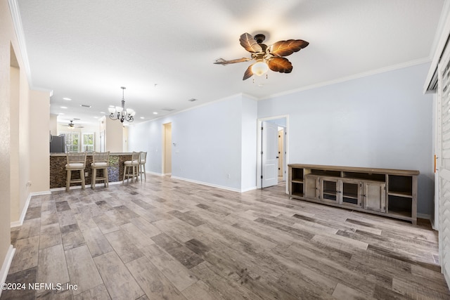 unfurnished living room featuring bar, ornamental molding, ceiling fan with notable chandelier, and hardwood / wood-style floors