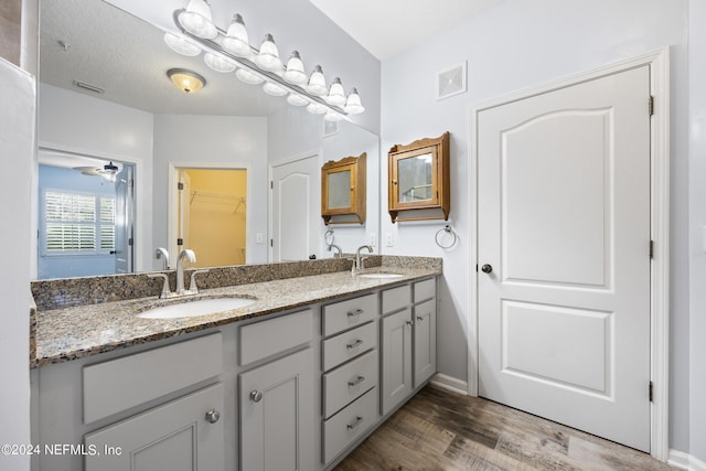 bathroom featuring vanity, hardwood / wood-style floors, a textured ceiling, and ceiling fan