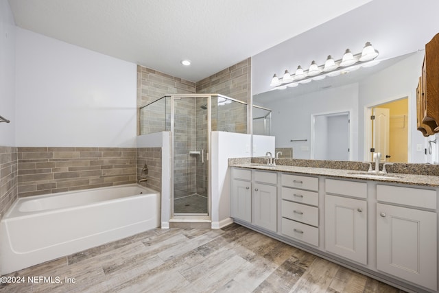 bathroom with vanity, a textured ceiling, independent shower and bath, and wood-type flooring