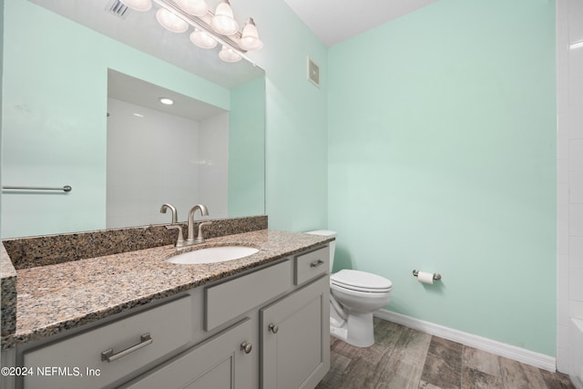 bathroom with vanity, wood-type flooring, and toilet