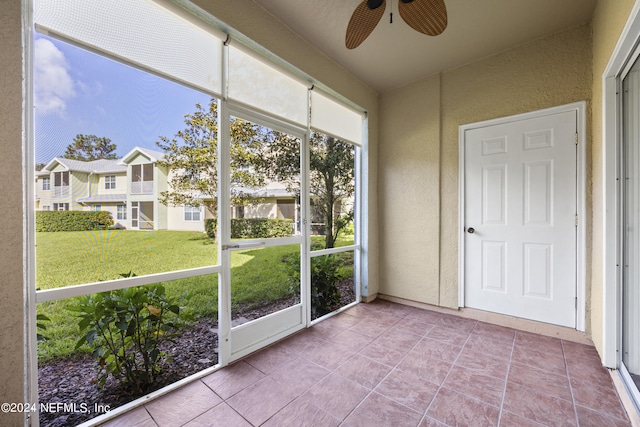 unfurnished sunroom featuring ceiling fan