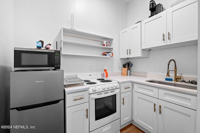 kitchen featuring light hardwood / wood-style floors, white cabinets, sink, and white appliances