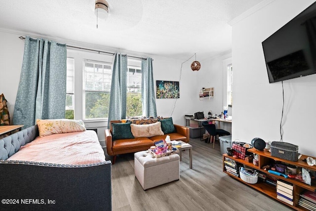 living room featuring ornamental molding, wood-type flooring, and ceiling fan