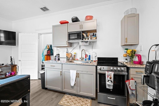 kitchen featuring gray cabinetry, crown molding, and stainless steel range oven