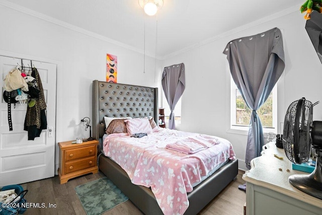 bedroom with hardwood / wood-style floors and crown molding