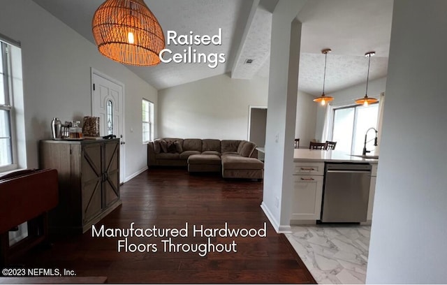 living room featuring hardwood / wood-style floors, a wealth of natural light, sink, and vaulted ceiling