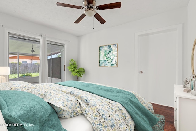 bedroom with ceiling fan, a textured ceiling, and dark hardwood / wood-style floors