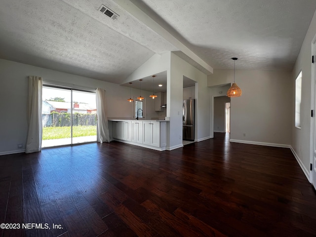 unfurnished living room with vaulted ceiling with beams, a textured ceiling, sink, and wood-type flooring