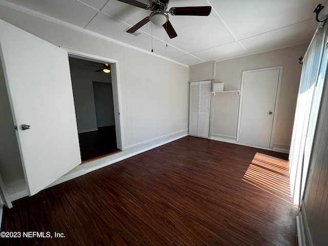 unfurnished bedroom with ceiling fan and dark hardwood / wood-style flooring