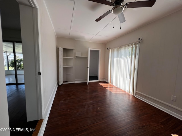 unfurnished bedroom featuring multiple windows, dark hardwood / wood-style floors, and ceiling fan