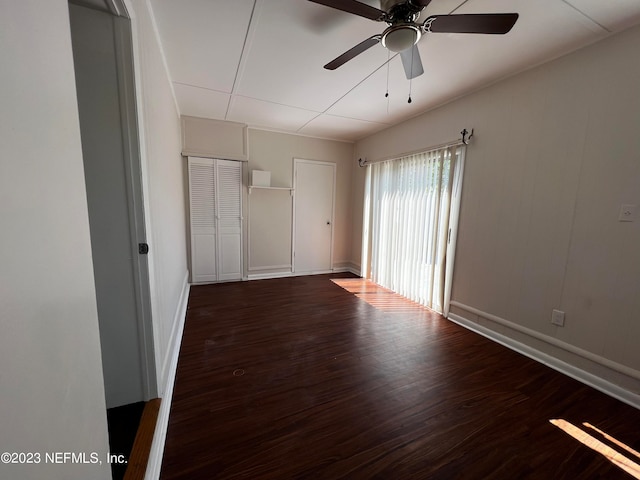 unfurnished bedroom featuring dark wood-type flooring and ceiling fan