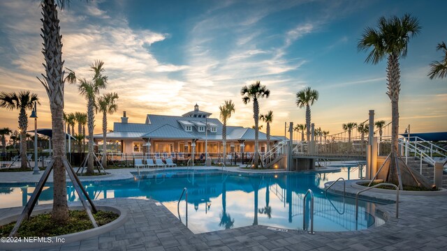 pool at dusk featuring a patio