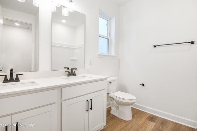 bathroom featuring wood-type flooring, vanity, and toilet