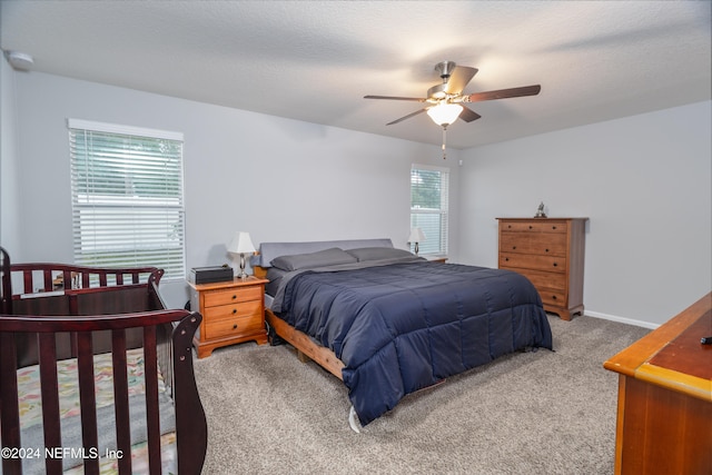 carpeted bedroom featuring a textured ceiling and ceiling fan