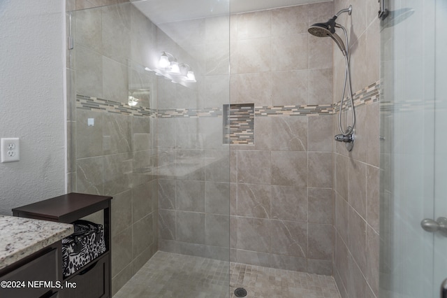 bathroom with a shower with door and vanity