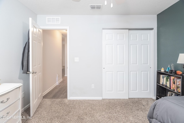 bedroom with a closet, carpet flooring, and a textured ceiling