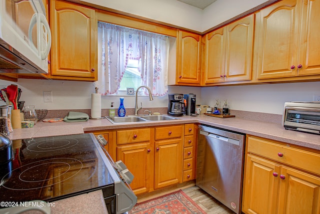 kitchen with sink, light hardwood / wood-style floors, and white appliances