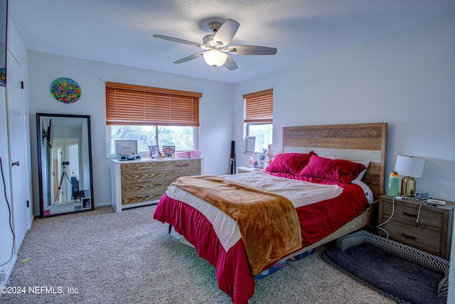 carpeted bedroom featuring a textured ceiling and ceiling fan