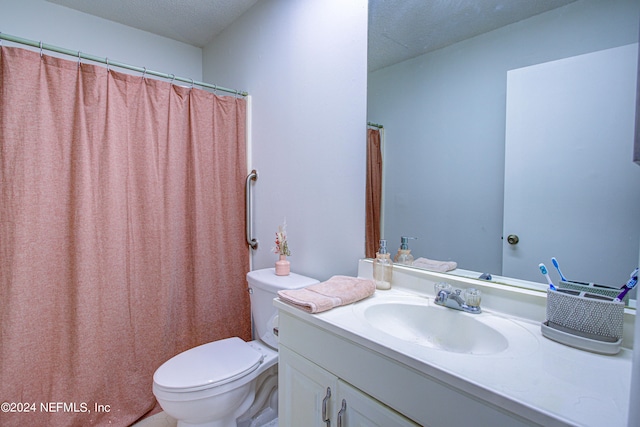 bathroom with vanity, toilet, a textured ceiling, and walk in shower