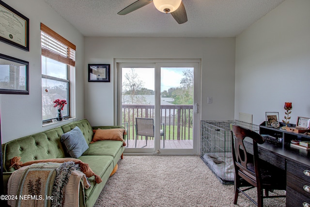 carpeted living room with ceiling fan, a textured ceiling, and a wealth of natural light