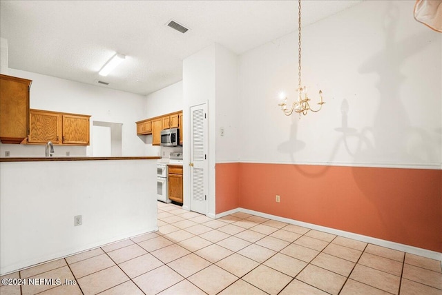 kitchen featuring hanging light fixtures, light tile patterned floors, a textured ceiling, a chandelier, and white electric stove