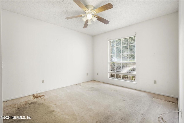 carpeted empty room featuring a textured ceiling and ceiling fan