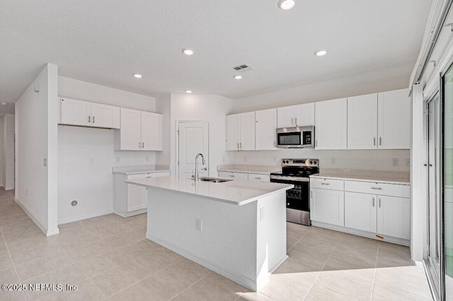 kitchen with sink, stainless steel appliances, an island with sink, and white cabinets