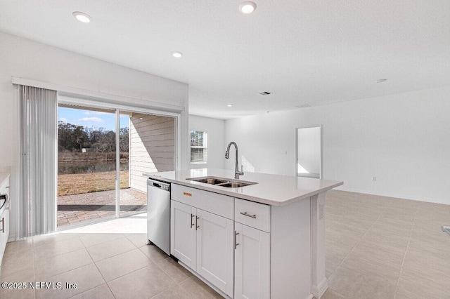 kitchen with sink, dishwasher, white cabinetry, a center island with sink, and light tile patterned flooring