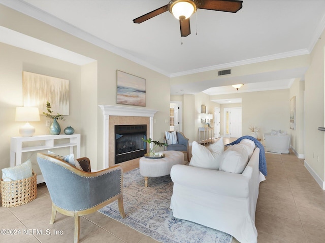 living room featuring crown molding, light tile patterned flooring, and a tile fireplace