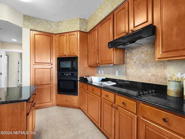 415 N Ocean Grande Dr Unit 102, Ponte Vedra Beach, FL 32082 - kitchen with black appliances, a textured ceiling, dark stone counters, decorative backsplash, and light tile patterned floors