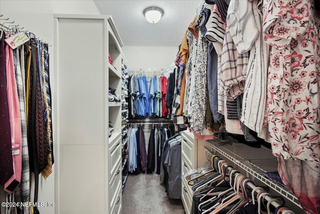 walk in closet featuring dark colored carpet