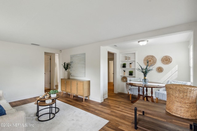 living room featuring dark hardwood / wood-style flooring and built in features