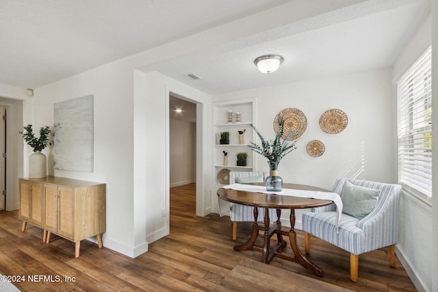 dining area with dark hardwood / wood-style flooring and built in features