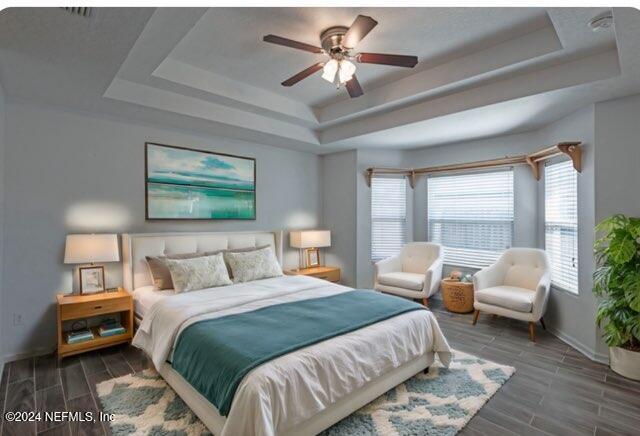 bedroom featuring a raised ceiling and ceiling fan