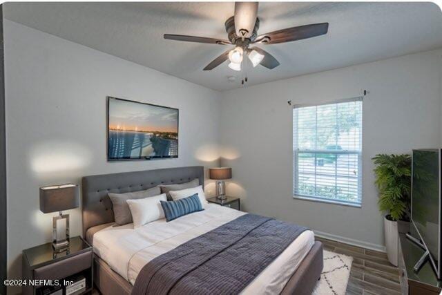 bedroom with dark wood-type flooring and ceiling fan