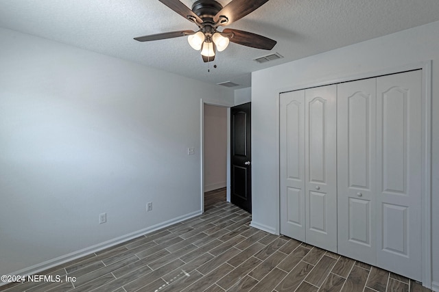 unfurnished bedroom with ceiling fan, a textured ceiling, and a closet