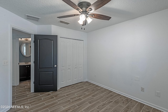 unfurnished bedroom with ceiling fan, a closet, and a textured ceiling