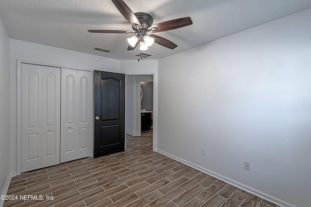 unfurnished bedroom featuring ceiling fan, a textured ceiling, and a closet