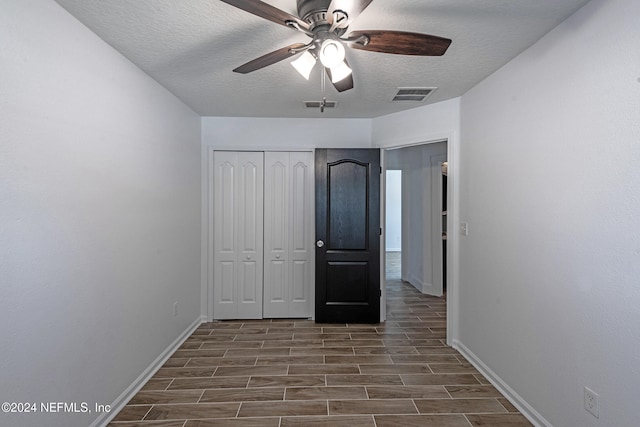 unfurnished bedroom with ceiling fan, a closet, and a textured ceiling