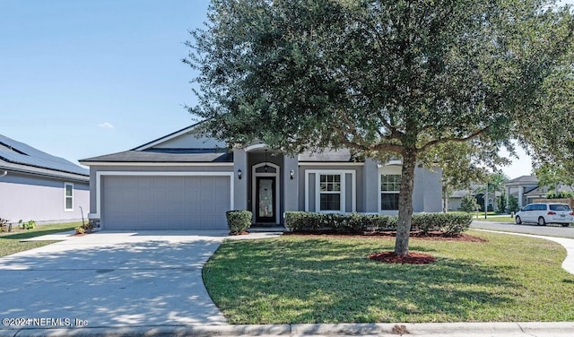 view of front of home with a garage and a front lawn